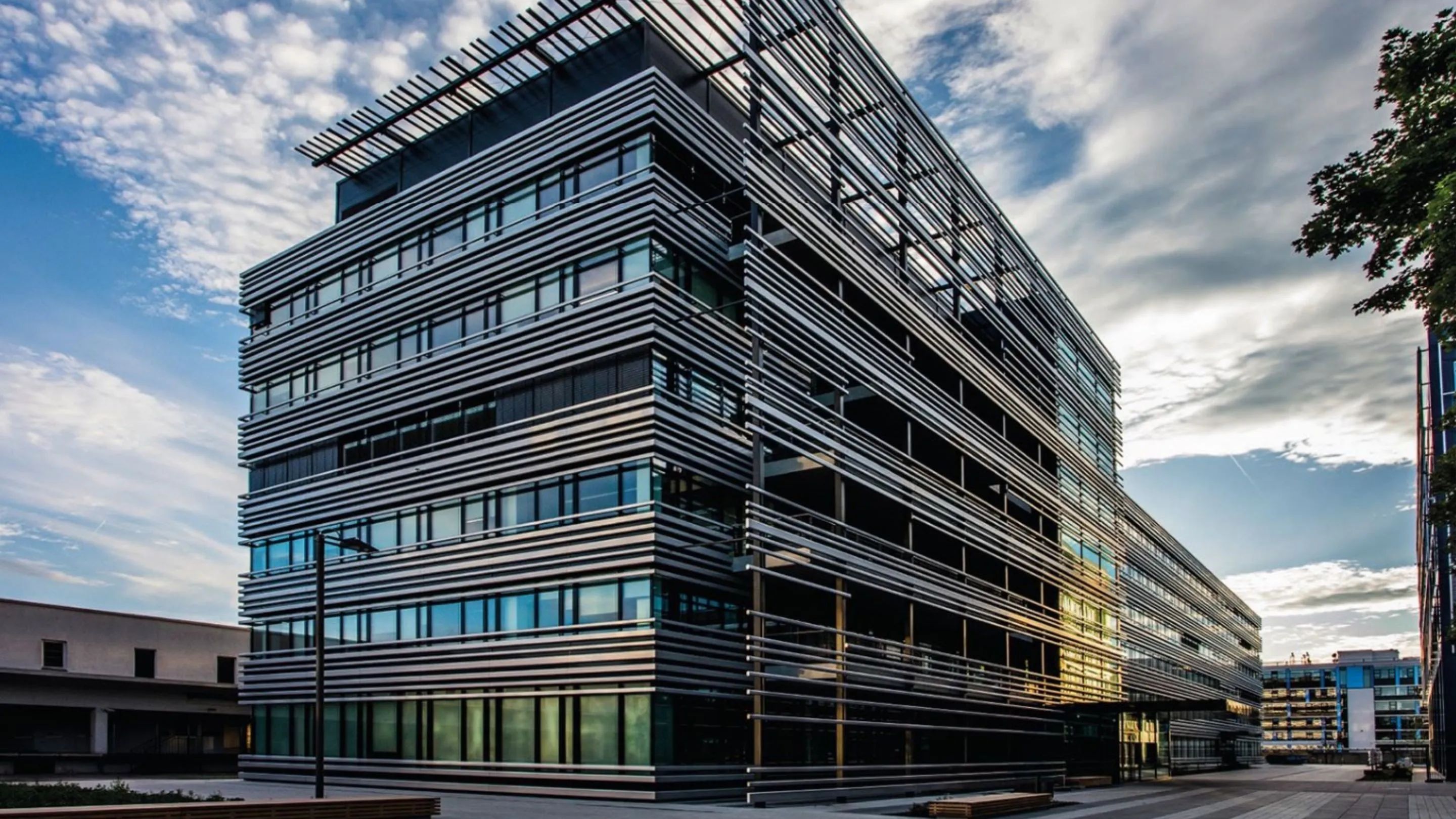 Rohde & Schwarz headquarters in Munich, with its glass and metal facade in the evening light